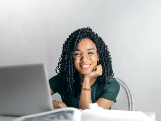 woman smiling at camera while on her laptop