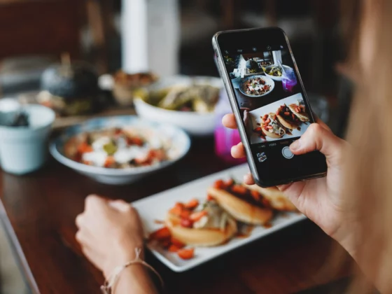 image of a woman taking a photo of her food with a phone