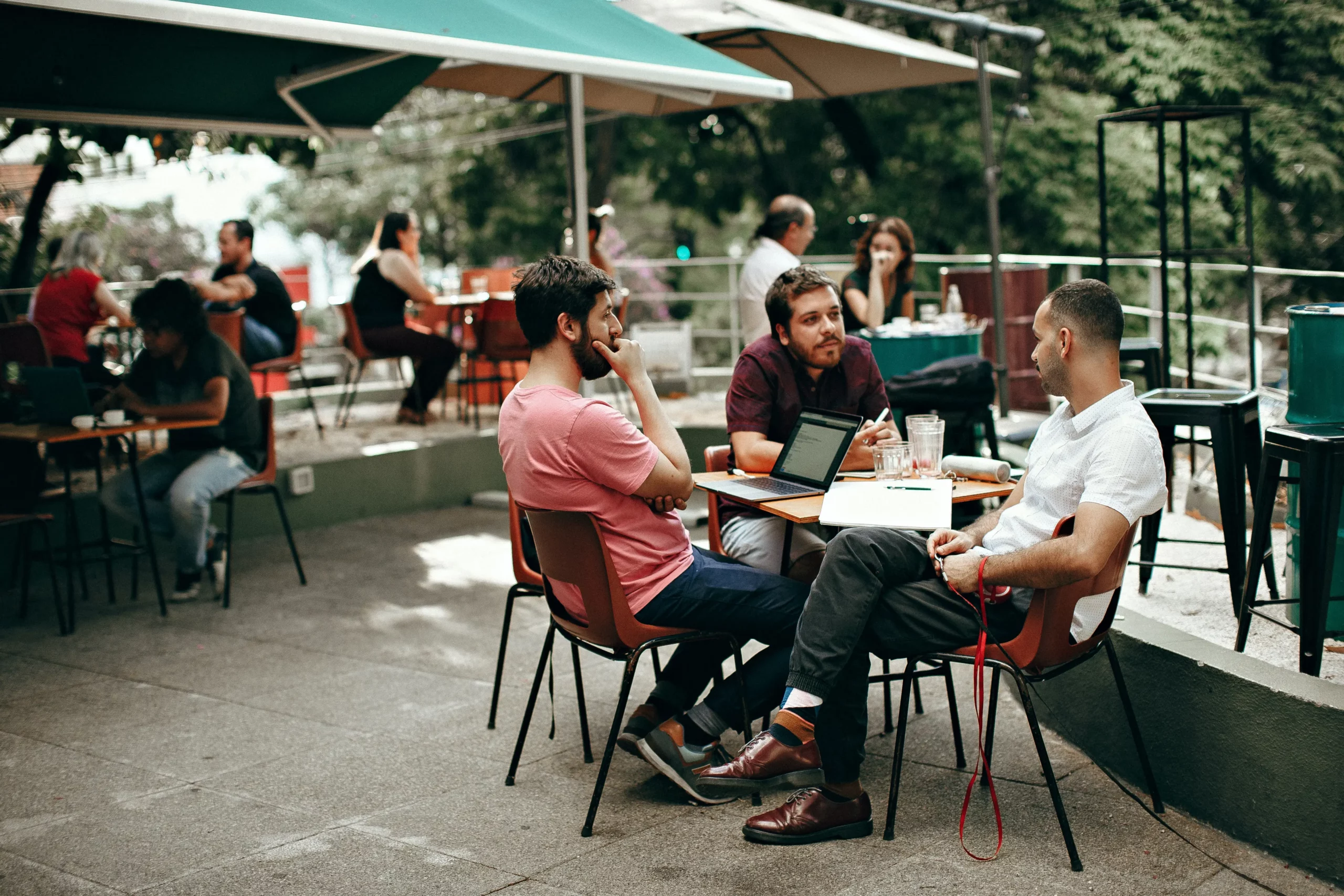 men sat at a table talking in a restaurant