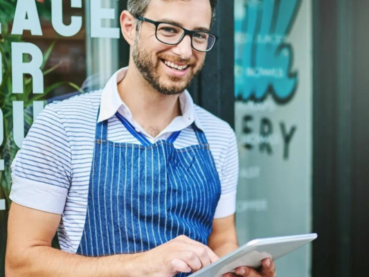 staff member outside restaurant with a tablet