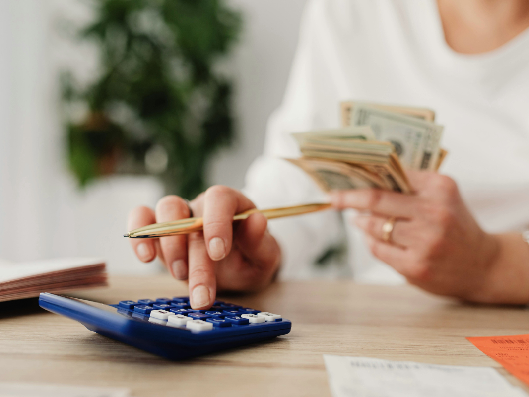 Person counting cash and using calculator