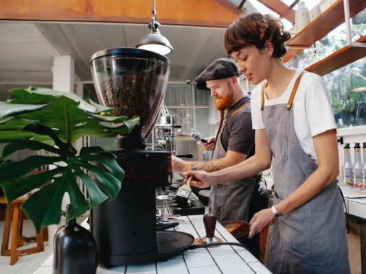 Two employees using coffee machine