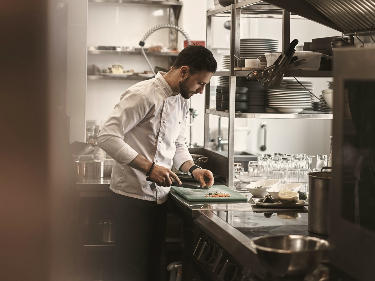 Chef cutting food in a restaurant kitchen