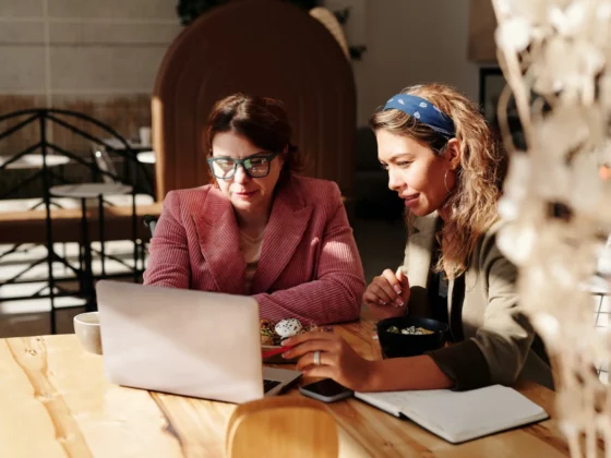 two women looking at laptop in a cafe