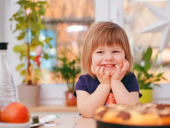 child smiling at a dinner table