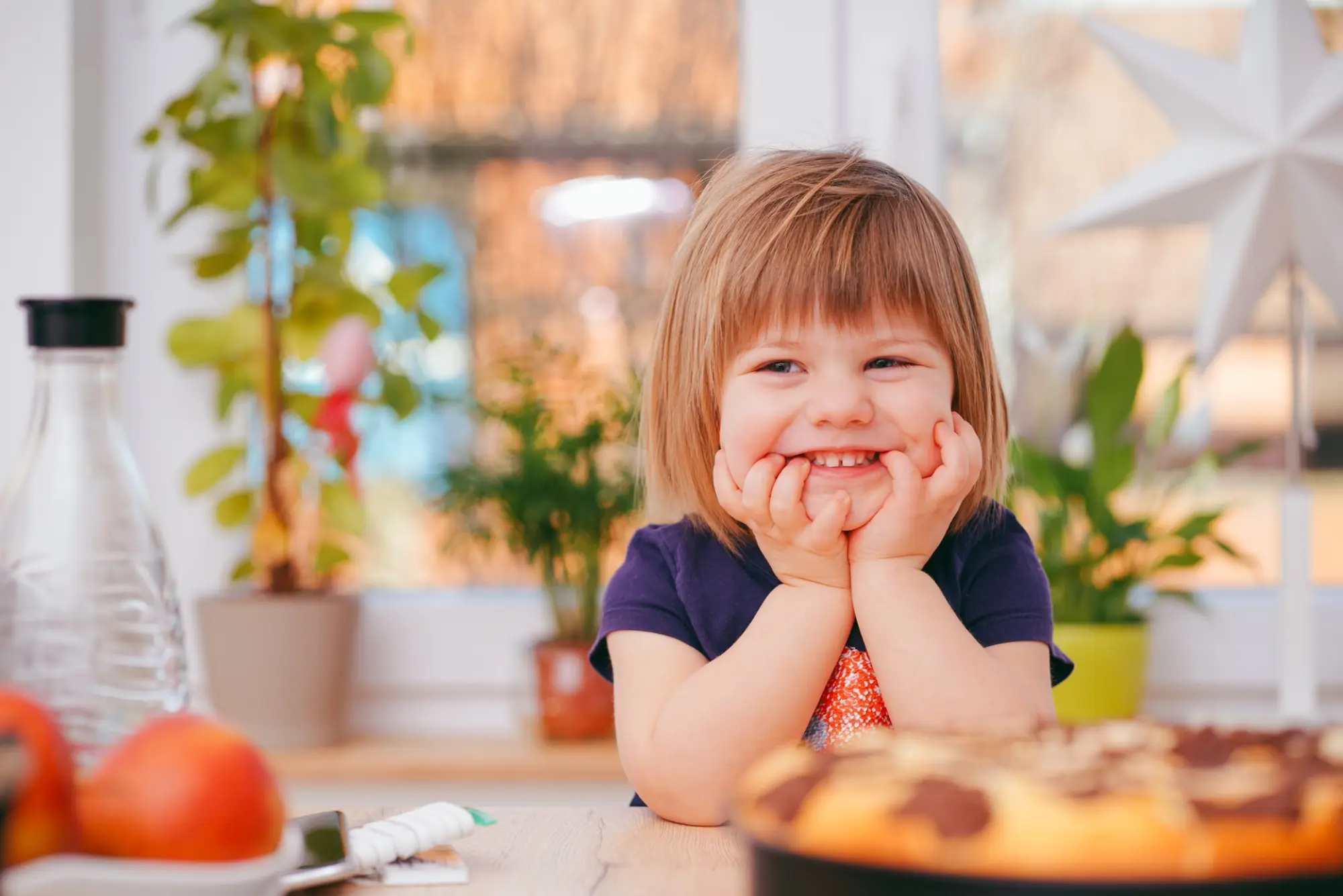 child smiling at a dinner table