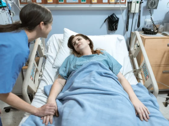 patient laying in hospital bed with nurse