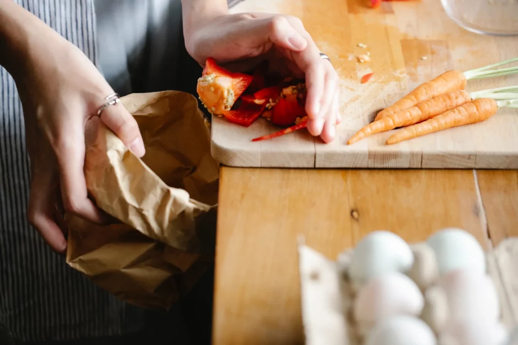 close up of woman putting food waste in bin