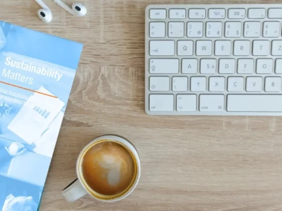 top down image of computer desk with coffee and book