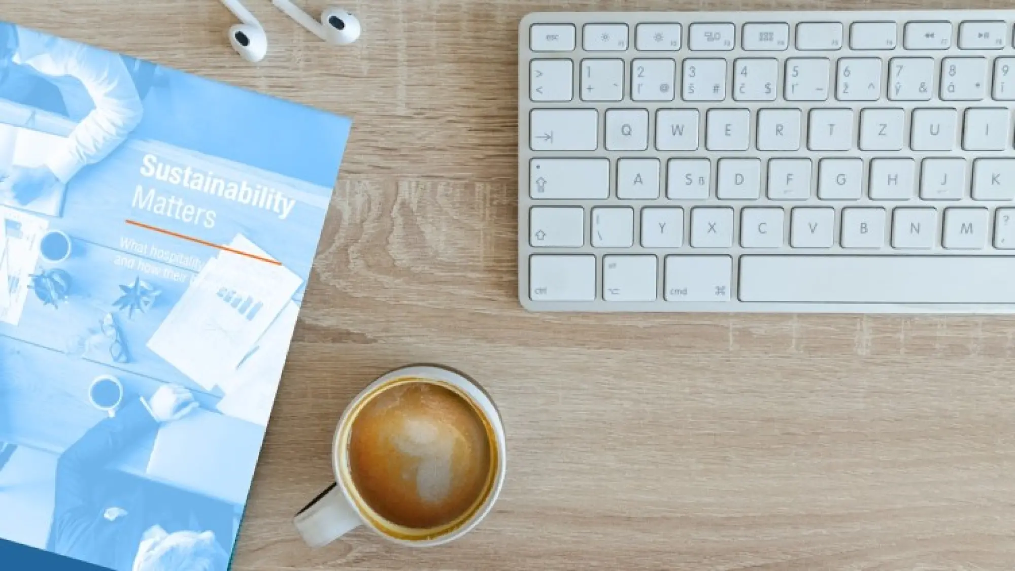 top down image of computer desk with coffee and book