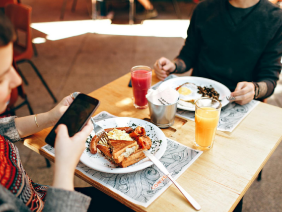 image of someone taking a photo of their lunch while eating in a restaurant